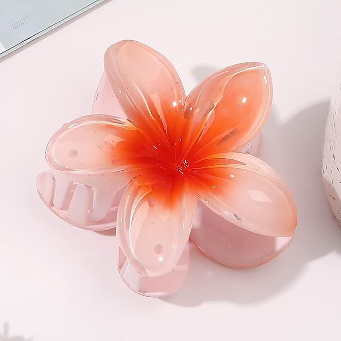 Pink plumeria flower hair clip with a glossy finish, tropical and feminine accessory